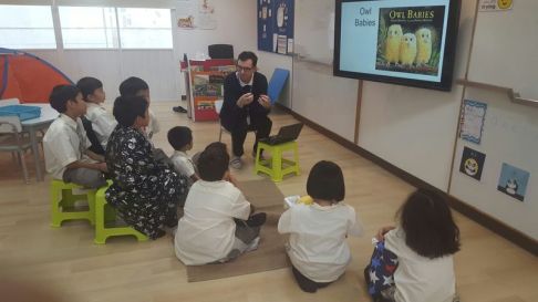 teacher-daniel-reading-stellar-book-baby-owls-with-primary-school-students-at-singapore-international-school-sisb-chiang-mai-thailand